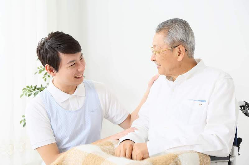 高齢男性に優しく話しかける男性